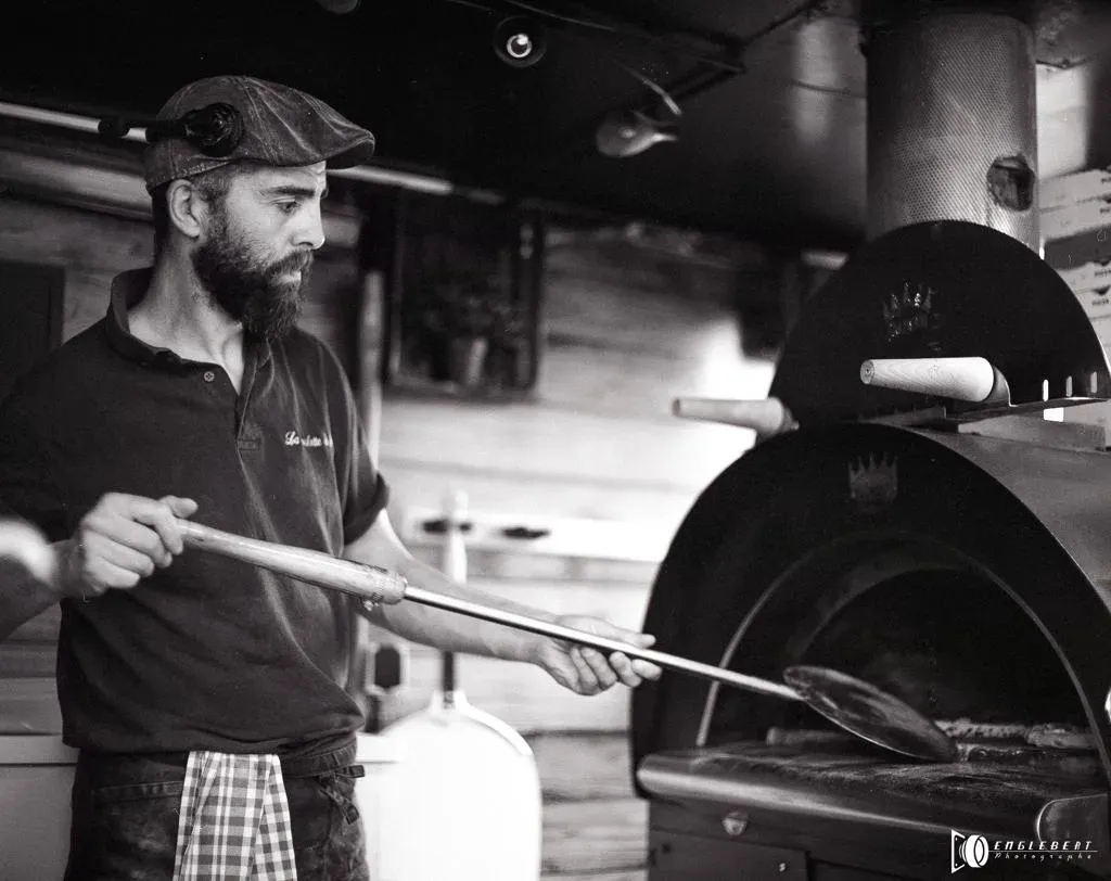 photo de la roulotte à pizza en noire et blanc préparation d'une pizza