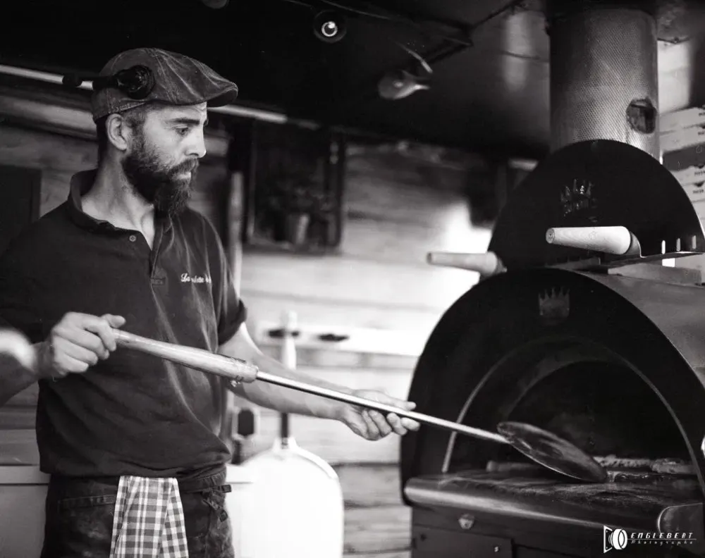 photo de la roulotte à pizza en noire et blanc préparation d'une pizza